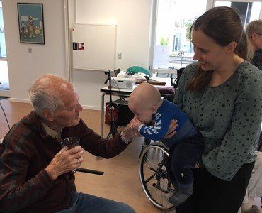  Baby, mor og smilende ældre mand på et plejehjem